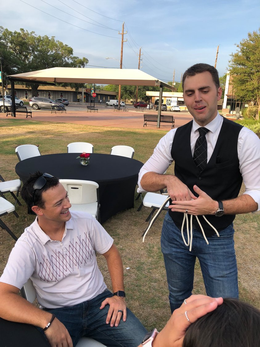 Justin Gessel, a street magician, performs a rope trick while Jameson Davitz watches at the Date Night July 22 at Katy Harvest Plaza..